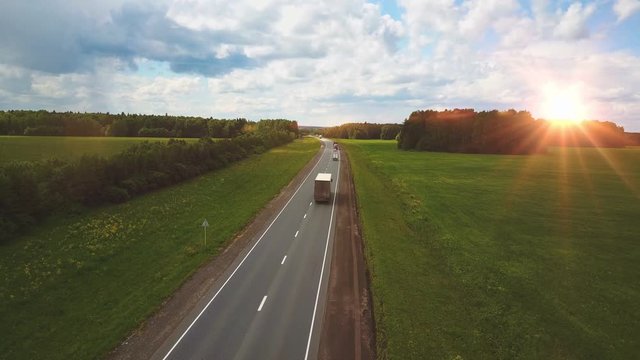Beautiful landscape with a ride on the highway the trucks and a few cars at sunset. aerial view
