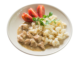 Pork goulash with pasta and sliced tomato isolated on white background