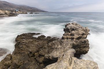 Fototapeta na wymiar Leo Carrillo State Beach rocky point with motion blur surf in Malibu, California.
