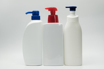 Three white bottles with red and blue pump