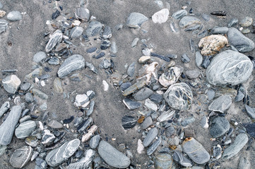 rocks and grey sand beach, background texture