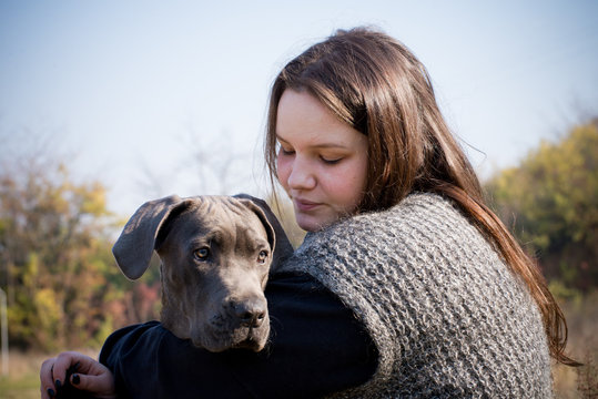 Girl and her gray cane corso puppy