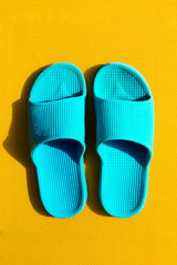 Beautiful Blue Flip Flops on Yellow Vibrant Vivid Background. Summer Travel Vacation Concept. Flat Lay.