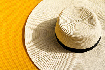 Fototapeta na wymiar Beautiful straw hat with on yellow vibrant vivid background. Top View. Summer Travel Vacation Concept.