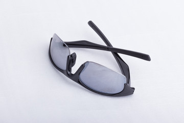 A pair of black, athletic sun glasses on a white surface