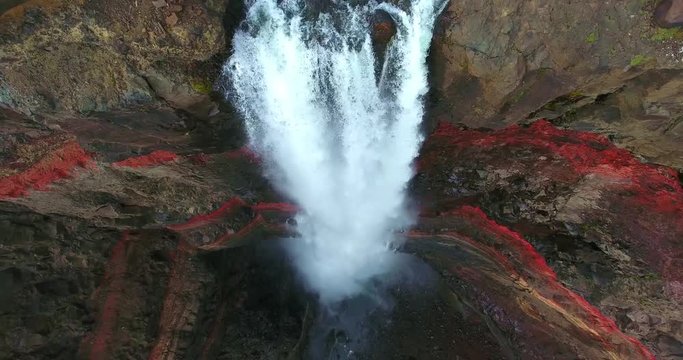 Frothing Waterfall Plunging Over Cliffs With Red Layers of Clay Between the Basaltic Layers.