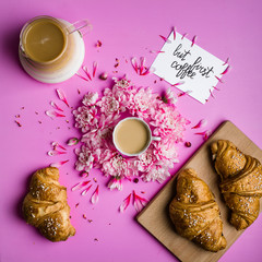 coffee and croissant on a pink background