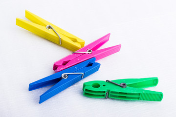 Four colorful clothespins on a white surface