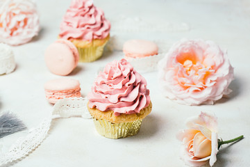 Pink cupcakes with roses and macaroons. Festive and bright. Wedding Celebration concept.