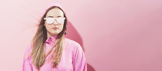 Girl in trendy painted glasses in pink jacket on a pink background