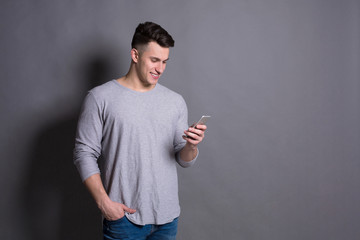 Handsome young man holding mobile phone.