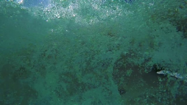 Man dives into the swimming pool - sun in the sky - slowmotion - shot from the bottom of the pool 