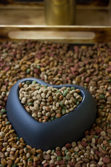 Obraz premium dry pet food in plastic heart bowl.