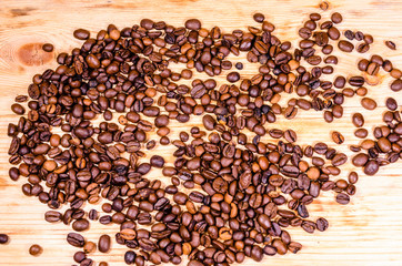 Pile of the roasted coffee beans on wooden table
