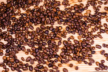 Pile of the roasted coffee beans on wooden table. Top view
