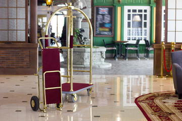 Luggage cart or hotel trolley in a luxury hotel on lobby zone. © sharafmaksumov