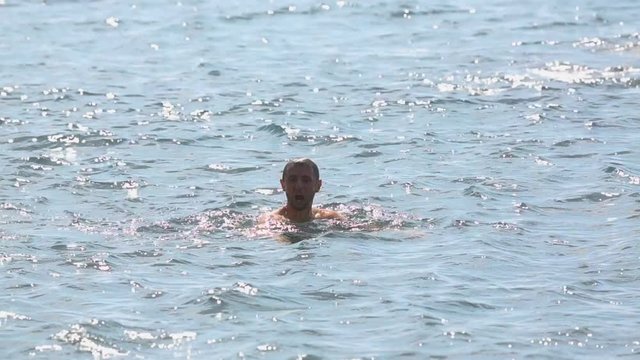 Brave man diving from cliff to troubled sea without fear, risky extreme jump
