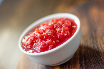 Indian chutney or mexican salsa in white ceramic bowl.