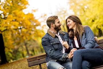 Young loving couple on the bench in the autumn park