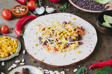 Vegetables, beans and cheese over tortilla bread - vegetarian mexican salad tacos.
