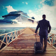 Man walks on a pier carrying a suitcase
