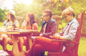 man with smartphone and friends at summer party