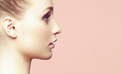 Naklejka premium Beauty close-up portrait of beautiful, fresh and healthy girl over orange background.