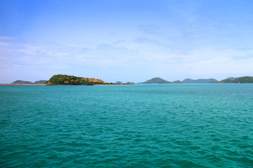 Thailand deep blue sea horizon seascape view at sunshine noon, wide nature scenery travel with white clouds sky. Green ocean wave ripple on windy summer season and small tree rock island landscape.