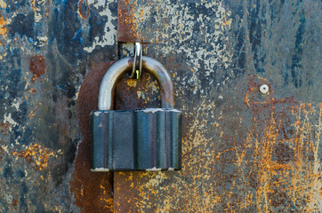 Old padlock on rusty gate