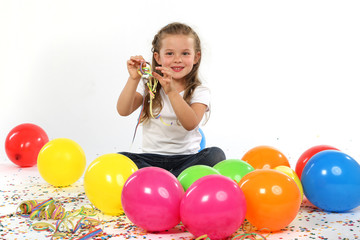 Fototapeta na wymiar Kleines Mädchen mit Luftballons, Konfetti und Luftschlangen
