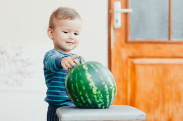 Fototapeta premium A little boy enjoys watermelon