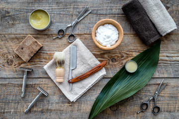 Barber workplace. Shaving brush, razor, foam, sciccors on wooden table background top view