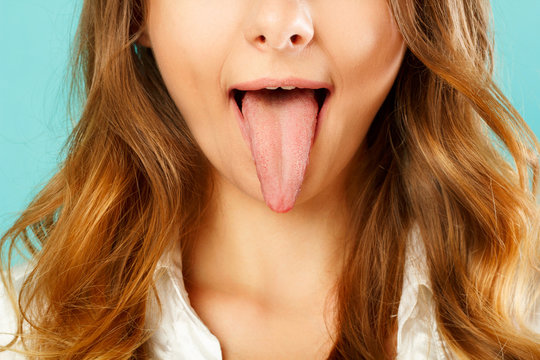 close up of healthy woman tongue over blue background