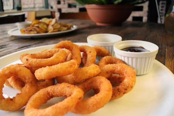Fried Onion Rings and sauces on wooden table