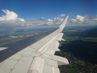 Obraz premium Wing of an airplane over the city