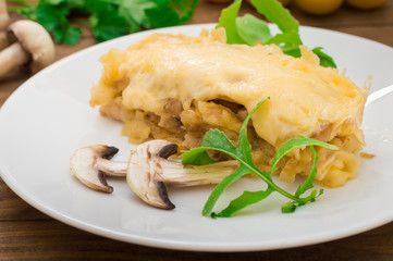 Hot Julienne with juicy chicken, mushrooms, cream sauce and cheese. Meat appetizer. Wooden background. Top view. Close-up