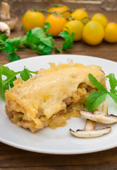 Hot Julienne with juicy chicken, mushrooms, cream sauce and cheese. Meat appetizer. Wooden background. Top view. Close-up