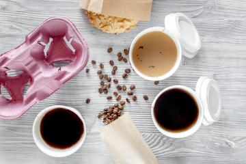 Coffee to go. Coffee cups with cover, coffee beans and cookies on wooden table backound top view