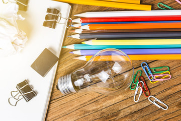 great idea concept with crumpled office paper and light bulb standing on table