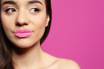 Beautiful young woman with lips makeup on color background