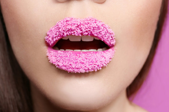 Lips of beautiful young woman covered with sugar, closeup