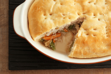 Baking dish with turkey pot pie on table, closeup