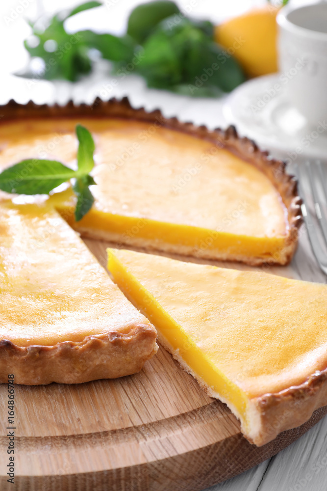 Poster wooden plate with delicious lemon pie on table, closeup