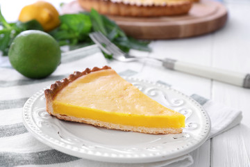 Plate with delicious lemon pie on table, closeup