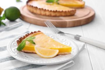 Plate with delicious lemon pie on table, closeup