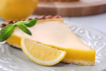 Plate with delicious lemon pie on table, closeup