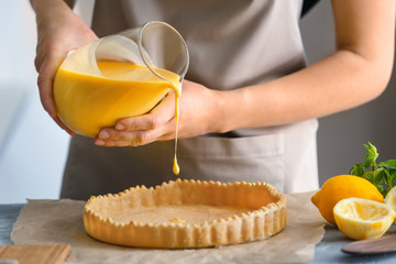 Woman cooking lemon pie in kitchen, closeup