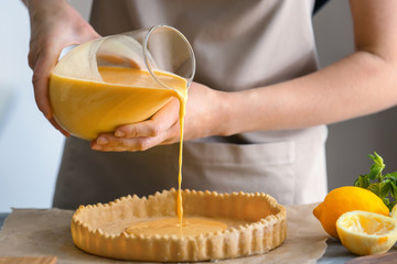 Woman cooking lemon pie in kitchen, closeup