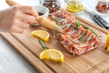 Woman preparing pork ribs, closeup