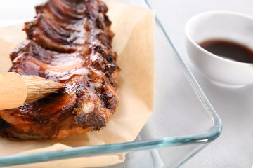 Baking tray with delicious pork ribs on table, closeup